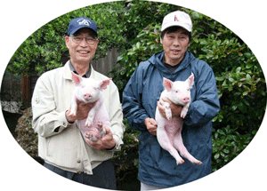「つくば豚」を抱く中野会長（左）と萩島氏（右）